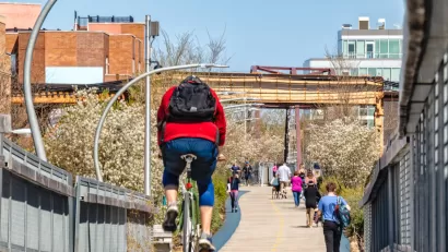 People on bikes and walking on 606 Bloomingdale Bike Trail on sunny day in Chicago, Illinois.