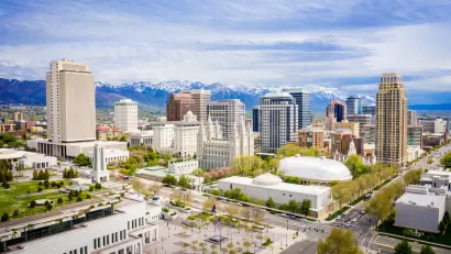 Aerial view of downtown Salt Lake City, Utah with snow-capped mountains in background.