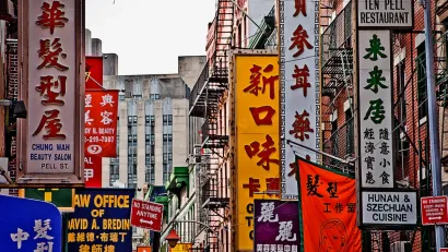 Block packed with Chinese-and English-language marquees and signs in New York City's Chinatown.