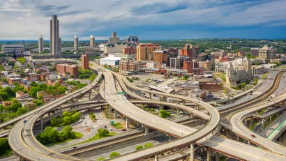 Aerial view of highways and downtown Albany skyline.