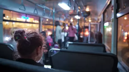 View of passengers on transit bus at night.