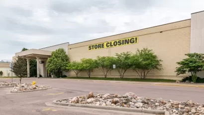 Large store in mall with yellow and black STORE CLOSING sign on front.