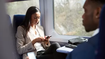 Close-up of two passengers in business clothes sitting face to face on speeding train
