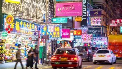 Cars and pedestrians on Hong Kong street at night.