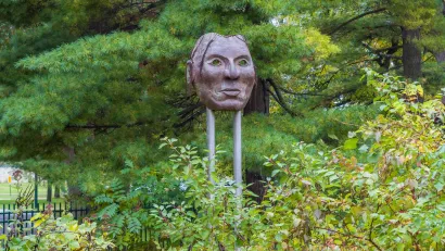 Bronze or metal Native American mask sculpture in park in Minnehaha County.
