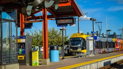 Yellow and silver Metro Transit light rail train pulling into outdoor station in Minneapolis, Minnesota.