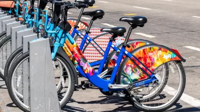 Bay Wheels bike share station full of colorful parked bikes on San Francisco street.