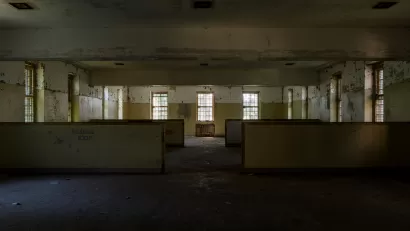 Abandoned wing of Creedmoor Hospital, Queens New York with long row of windows and 'Reading Room' visible on wall