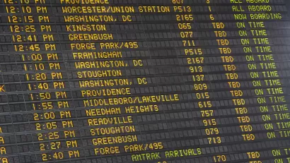 Close-up of old-fashioned trains departure board with yellow text on black background in Boston, Massachusetts train station.