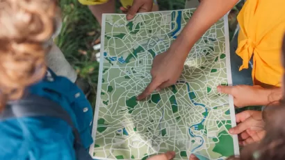 Group of children looking down at map.