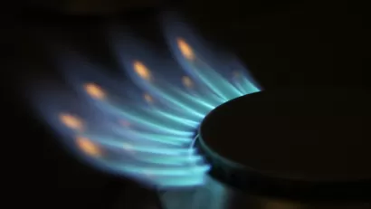 Close-up of natural gas stove burner with blue flames.