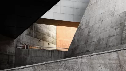 Concrete Brutalism building with slanted walls and light visible through an atrium.
