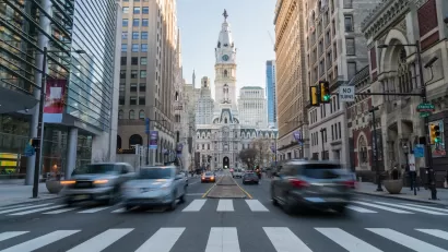 View from middle of crosswalk of Phialdelphia City Hall with blurred traffic.