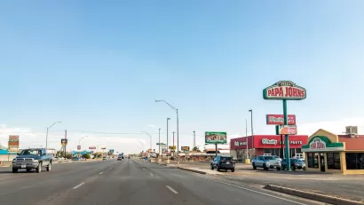Six-lane road with fast food and pizza restaurants in Alamogordo, New Mexico.