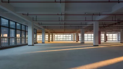 Large empty office building floor with columns and golden hour light.