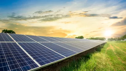 Photovoltainc solar panels in green grass field.