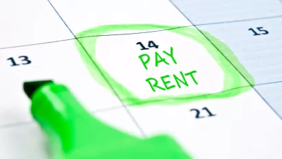Close-up of calendar with "Pay rent" written on day 14 and circled in green highlighter