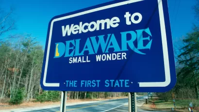 Blue "Welcome to Delaware" roadside sign.