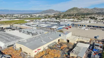Aerial view of large warehouses in Southern California with hills in background.