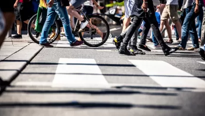 Low angle view of busy crosswalk with pedestrians and a bike.