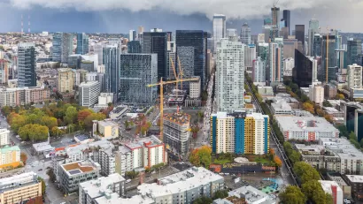 View of downtown Seattle with construction cranes and cloudy sky as seen from top of Space Needle.