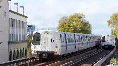 White BART trains passing each other on elevated track in Fruitvale, California.