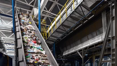 Conveyor belt in industrial recycling center with plastic materials.