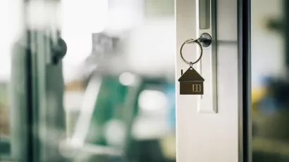 Close-up of house-shaped keychain in front door of home.