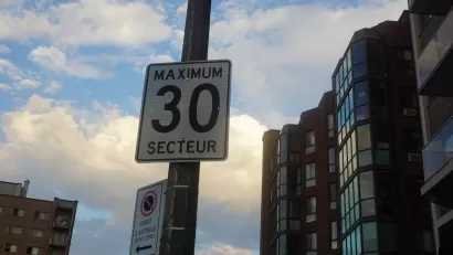Close-up of "Maximum 30 Secteur" speed limit sign on pot in Quebec, Canada.