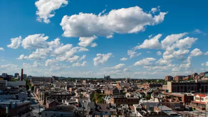 View of east Baltimore, Maryland low-slung brick buildings against a lightly cloudy blue sky