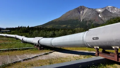 Ground level view of Alaska Pipeline oil pipeline near Prudhoe Bay, Alaska with bare mountains in background.
