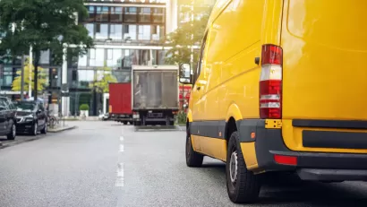View from rear of yellow delivery van on city street.