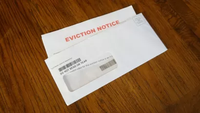 Eviction notice and envelope on wood floor.