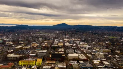 Aerial view of Eugene, Oregon at dusk with mountains in background.