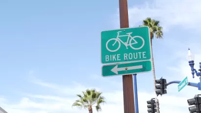 Close-up of green and white Bike Route sign with arrow in California.
