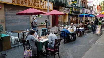 Patrons at restaurant in New York City eating at ourdoor tables in closed-off alleyway during Covid-19 pandemic in 2020.