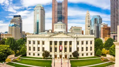 Ohio State Senate building nwith modern downtown Columbus skyscrapers in background.