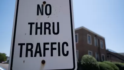 Close-up of white "No Thru Traffic" sign