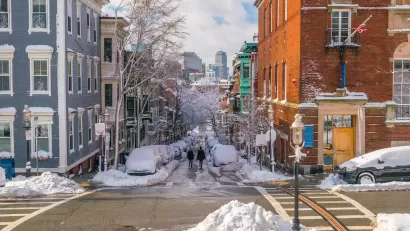 Snowy street scene with old residential buildings in Boston, Massachusetts.