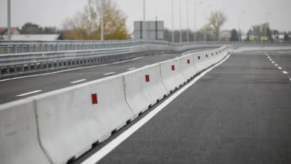 Row of concrete Jersey barriers running down the middle of a multi-lane road.
