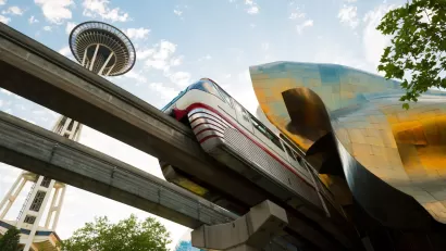 View from under track of Seattle monorail passing under Frank Gehry-designed Museum of Pop Culture with Space Needle in background
