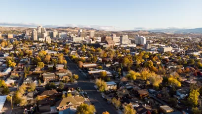 Aerial view of Reno, Nevada with homes in foreground and downtown buildings in background during autumn.