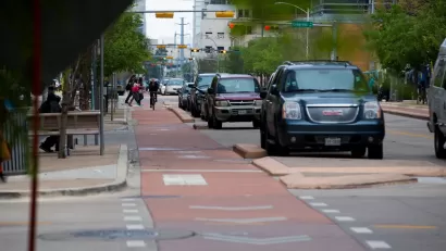 Red painted and curb-protected bike lane in downtown Austin, Texas.