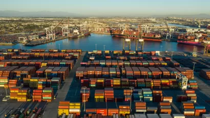 Aerial view of stacked shipping containers at golden hour at Port of Long Beach, California.