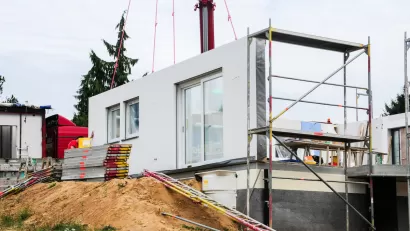 White modular home being built on dirt mound