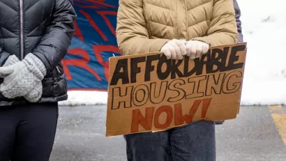 Close-up on protester holding Affordable Housing Now sign.