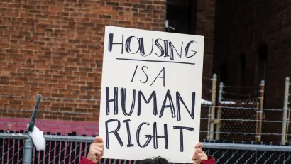 Close-up on handmade sign being held up at protest "Housing is a human right"