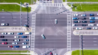 Bird-s eye view of multi-lane road intersection with medians and crosswalks.