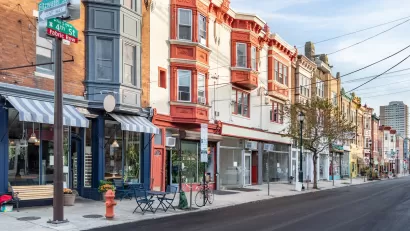 Row of three-story buildings with stores and restaurants with awnings on ground floor in Philadelphia, Pennsylvania.