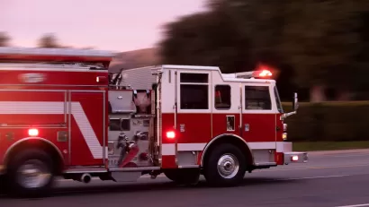 Red fire truck speeding down a street.